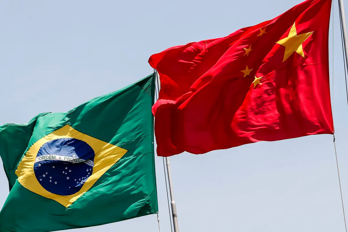 Bandeiras do Brasil e da China hasteadas lado a lado no vento